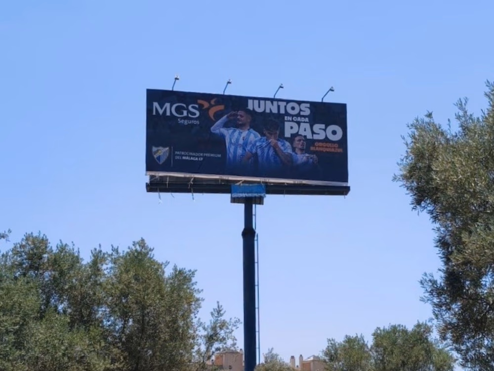 Monoposte publicitario 12x5 de MGS Seguros en la avenida Valle-Inclán de Málaga, con la creatividad del patrocinio al Málaga CF y el lema «Juntos en cada paso, orgullo blanquiazul»